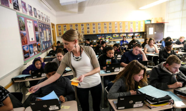 Janelle Baker hands out papers while her eighth-grade U.S. history class take a quiz at Valley Juni...