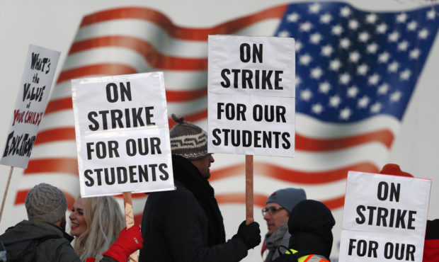 Teachers carry placards as they walk a picket line outside South High School early Monday, Feb. 11,...