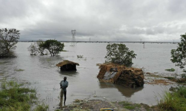 A man stands in flood waters following cyclone force winds and heavy rain near the coastal city of ...