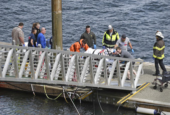 Emergency response crews transport an injured passenger to an ambulance at the George Inlet Lodge d...