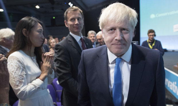 Boris Johnson walks to the stage, as rival Jeremy Hunt looks on after the announcement of the resul...