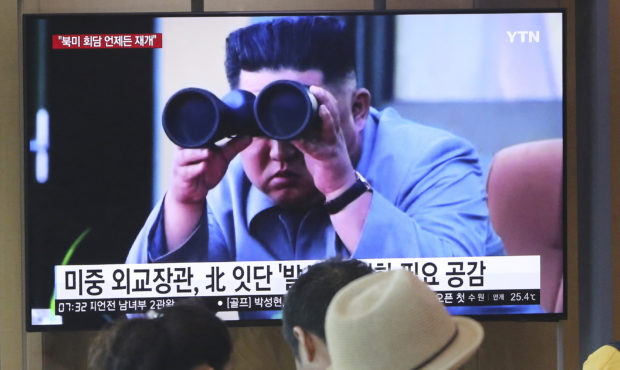 FILE - In this Aug. 2, 2019, file photo, people stand by a TV screen showing a file footage of Nort...