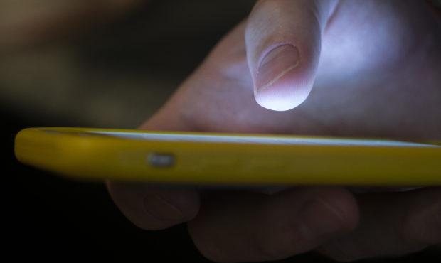 FILE - In this Aug. 11, 2019, file photo, a man uses a cell phone in New Orleans. Major phone compa...