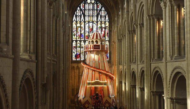 The giant ride is set up in front of a large stained glass window....