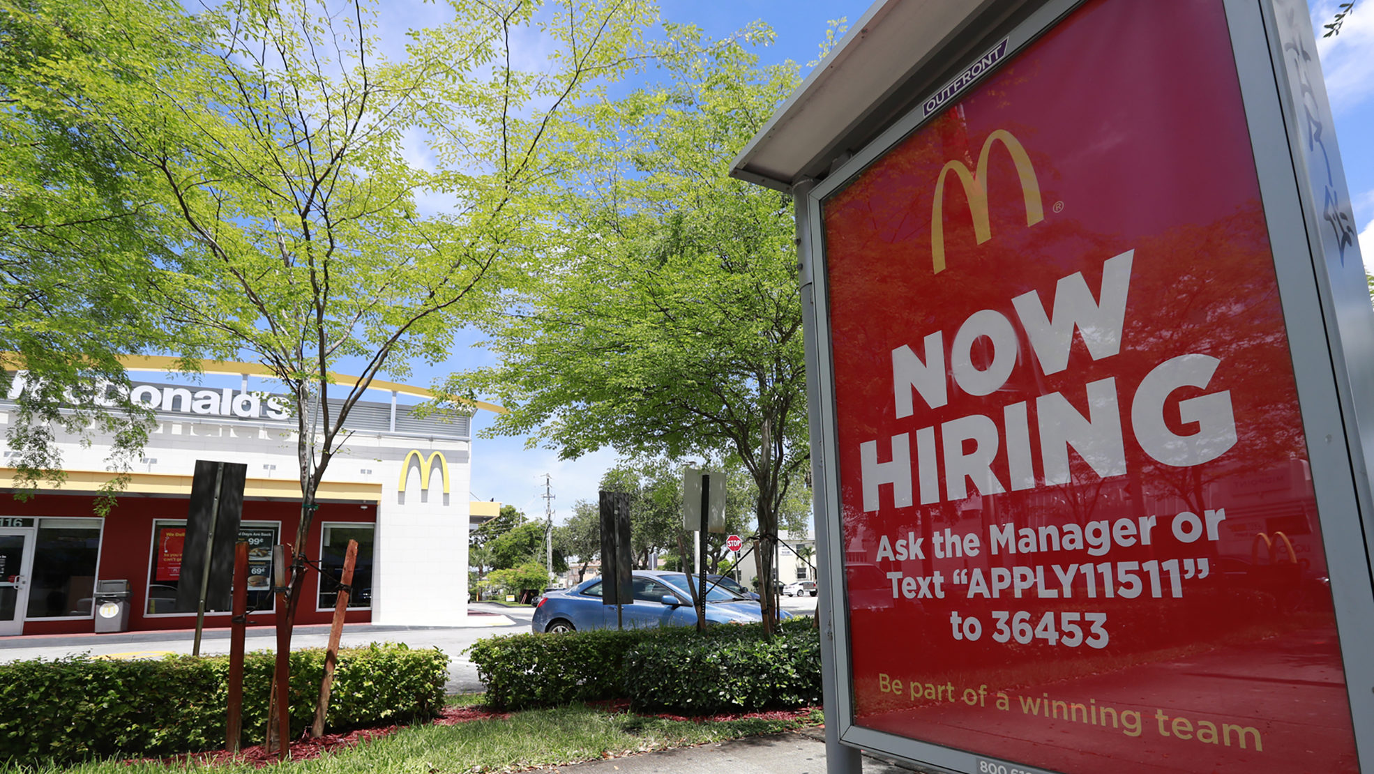 FILE - In this Monday, July 1, 2019, file photo, a "Now Hiring" sign appears on a bus stop in front...