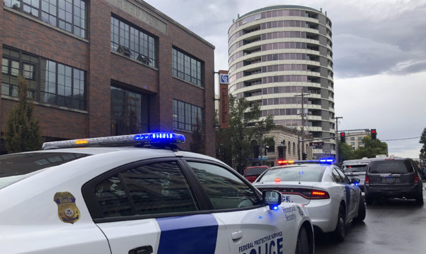 Police respond to a shooting at an apartment building, top rear, in Vancouver, Wash., Thursday, Oct...