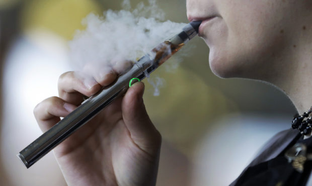 FILE - In this Oct. 4, 2019, file photo, a woman using an electronic cigarette exhales in Mayfield ...