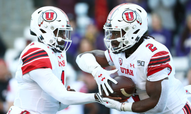 SEATTLE, WASHINGTON - NOVEMBER 02: Tyler Huntley #1 hands the ball off to Zack Moss #2 of the Utah ...