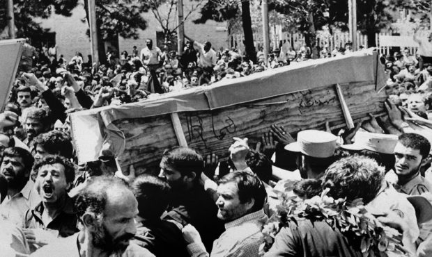 FILE - In this July 7, 1988 file photo, Iranian mourners carry one of 72 caskets to the Cemetery of...