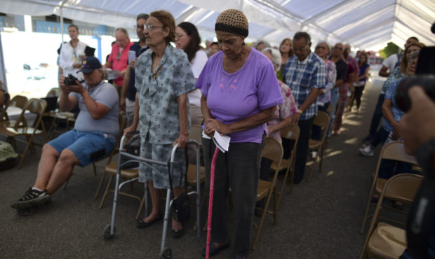 People attend an outdoor Mass under a tent set up near the Immaculate Concepcion Catholic Church, w...