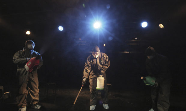 Workers wearing protective gears spray disinfectant as a precaution against a new coronavirus at a ...