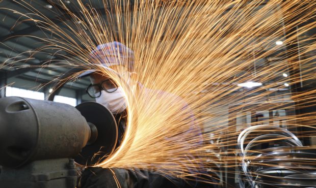 In this Monday, March 2, 2020, photo, a worker wearing a mask works at a factory producing bicycle ...
