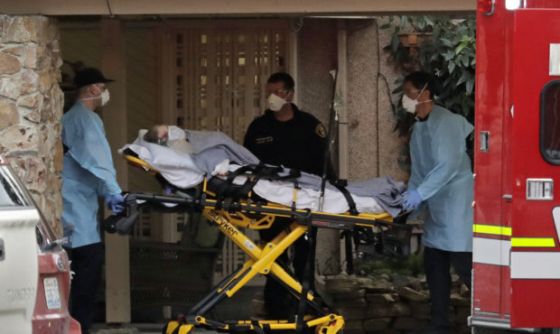 A patient is loaded into an ambulance, Tuesday, March 10, 2020, at the Life Care Center in Kirkland...
