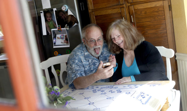 Seen through their kitchen window, Allan and Debbie Cameron contact their grandchildren via the int...