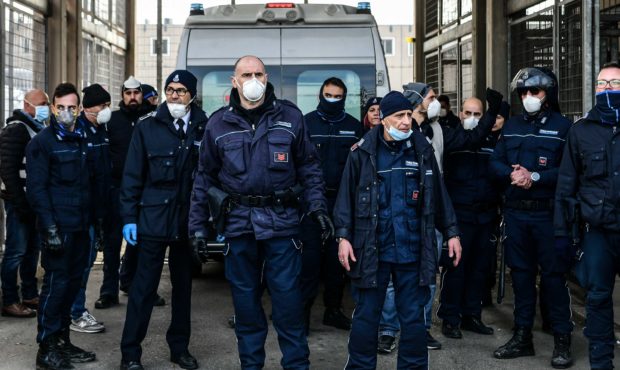 Prison Police officers stand guard after an ambulance (Rear) entered the SantAnna prison during a p...