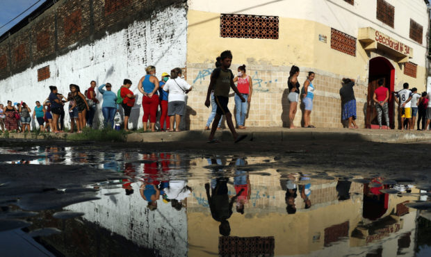 FILE - In this Tuesday, March 31, 2020 file photo, neighbors line up for free food staples outside ...