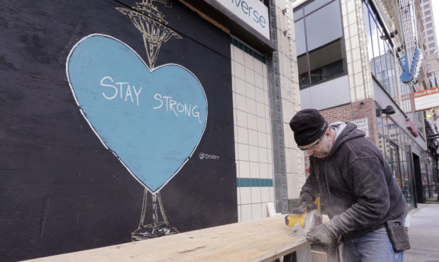 A carpenter, who declined to be identified, cuts plywood to cover a closed store where artwork in s...