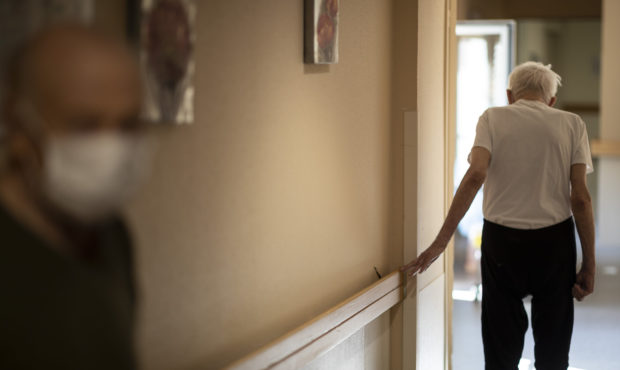 FILE - In this April 16, 2020, file photo, Richard Eberhardt walks along a corridor at a nursing ho...