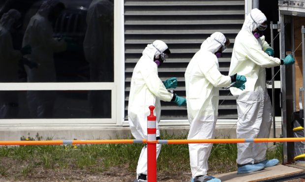 In this March 31, 2020 photo, cleaners unwrap their protective gear as they leave the Soldiers' Hom...
