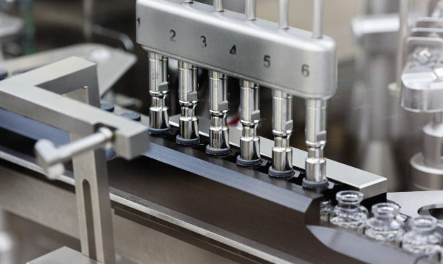 FILE - In this March 2020 photo provided by Gilead Sciences, rubber stoppers are placed onto filled...