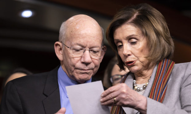 FILE - In this Jan. 29, 2020, file photo, House Speaker Nancy Pelosi of Calif., right, shows a note...