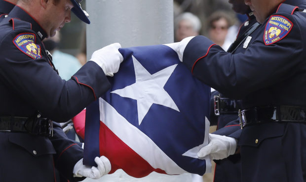 A Mississippi Highway Safety Patrol honor guard carefully folds the retired Mississippi state flag ...