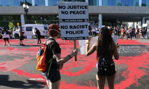 FILE - In this July 9, 2020, file photo, protesters gather in front of district attorney's office i...