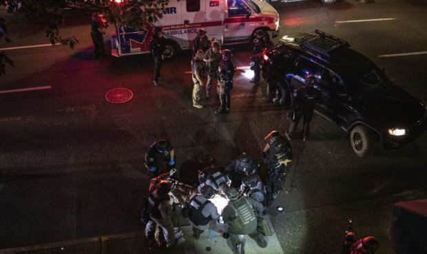 A man is treated after being fataly shot Saturday, Aug. 29, 2020, in Portland, Ore. It wasn’t cle...