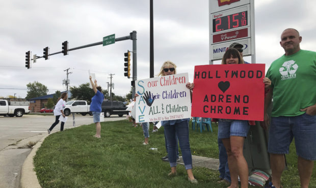 A group holds signs rallying in support of the “Save the Children” movement, calling for an end...