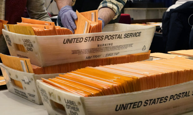 Election officials sort absentee and early voting ballots for counting inside Boston City Hall, Mon...