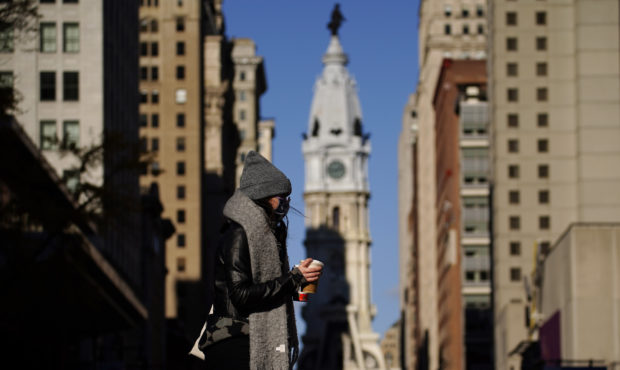 In this Nov. 18, 2020 photo, a person wearing a face mask crosses Broad Street in Philadelphia. As ...