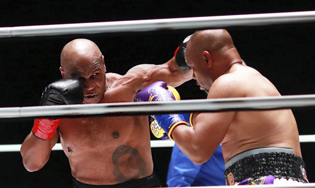 In a photo provided by Triller, Mike Tyson throws a punch during the third round against Roy Jones ...