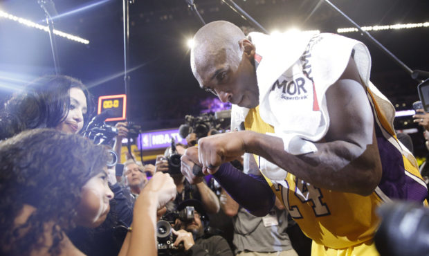 Los Angeles Lakers' Kobe Bryant, right, fist-bumps his daughter Gianna after the last NBA basketbal...