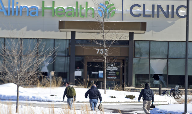 Law enforcement personnel walk toward the Allina Health clinic, Tuesday, Feb. 9, 2021, in Buffalo, ...