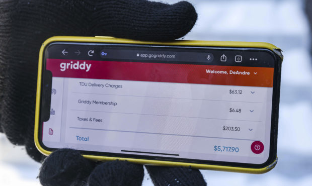 DeAndré Upshaw shows a $5,000 bill from Griddy on his cell phone for his 900-square-foot apartment...