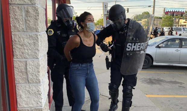 Police officers are shown arresting Des Moines Register reporter Andrea Sahouri after a Black Lives...