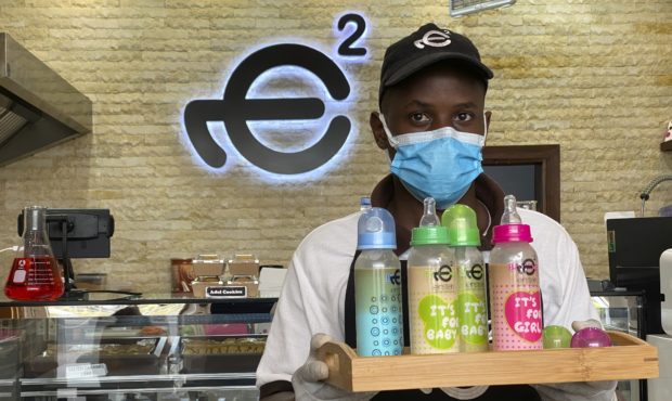 A waiter poses with a tray of baby bottles that he brought out from storage, at Einstein Cafe in Du...