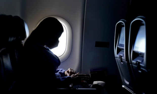 FILE - In this Wednesday, Feb. 3, 2021 file photo, a passenger wears a face mask during an airline ...