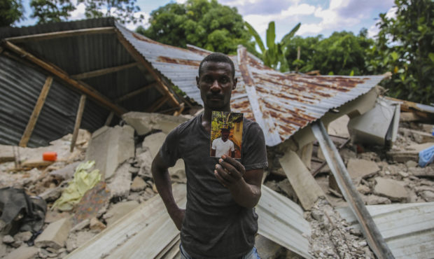 Greogory Andre shows a photo of his brother Remossa Andre, who died during the earthquake in Camp-P...