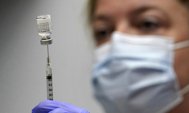 FILE - In this March 2, 2021, file photo, Hollie Maloney, a pharmacy technician, loads a syringe wi...