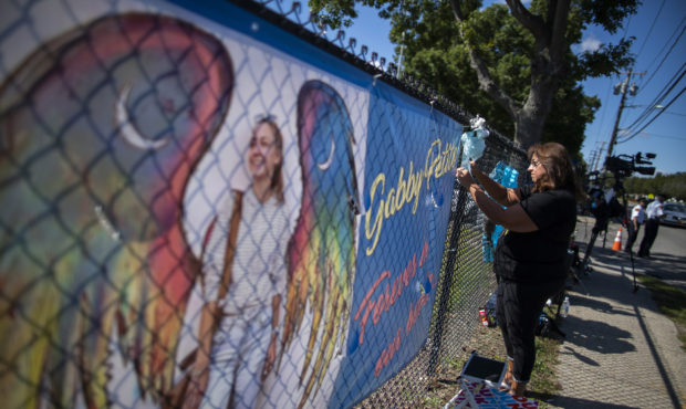 Woman places a decoration near a poster after attending the funeral home viewing of Gabby Petito at...