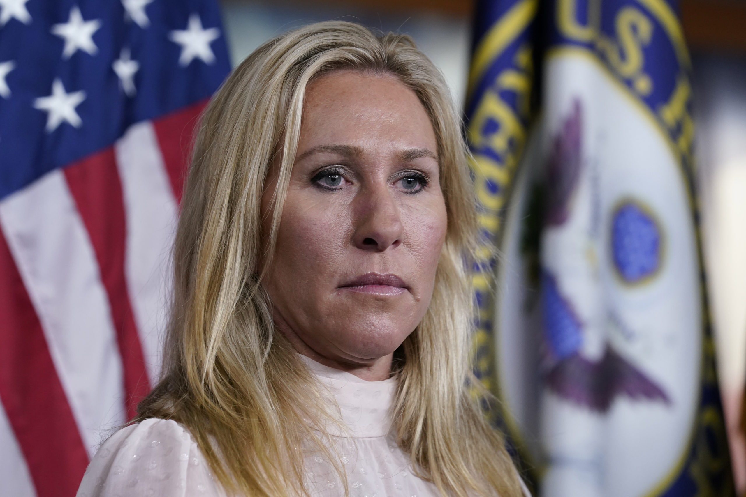 FILE - Rep. Marjorie Taylor Greene, R-Ga., listens during a news conference about the treatment of ...