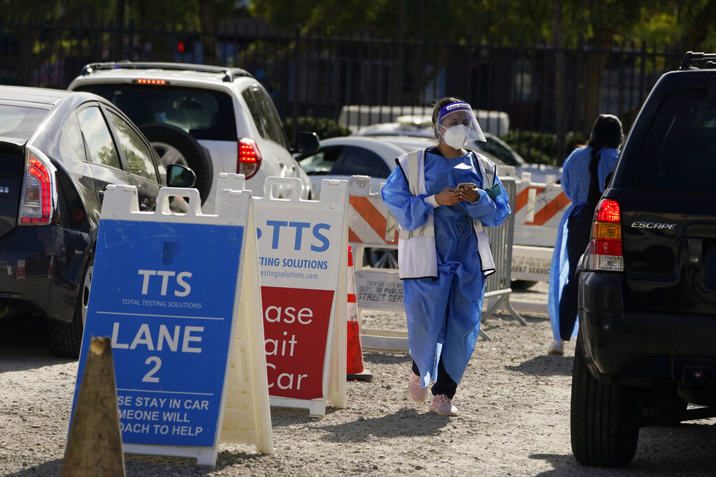 Workers wear protective equipment at a COVID-19 testing site Wednesday, Jan. 26, 2022, in the Boyle...
