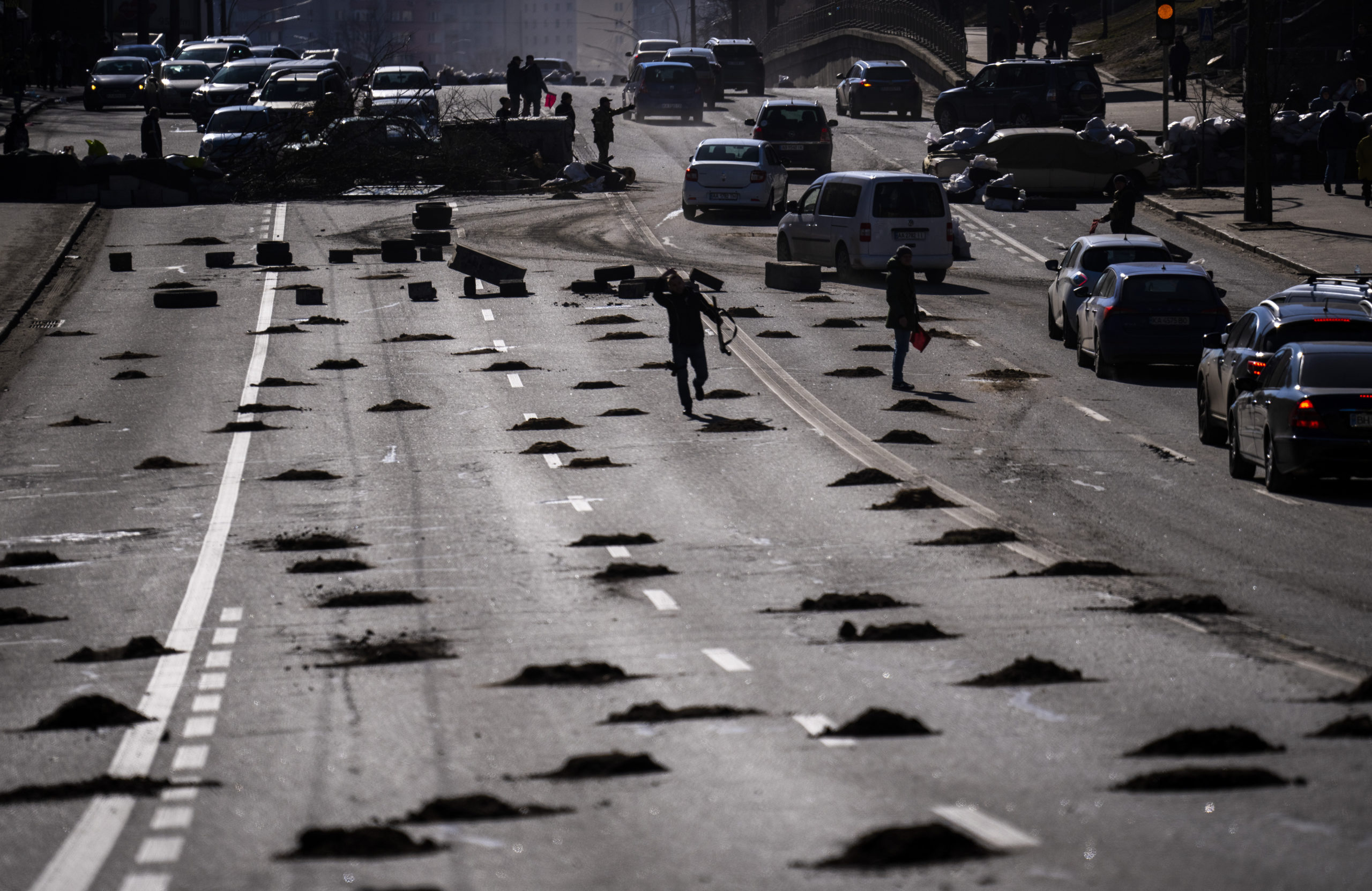 Cars are stopped at a roadblock set by civil defensemen at a road leading to central Kyiv, Ukraine,...