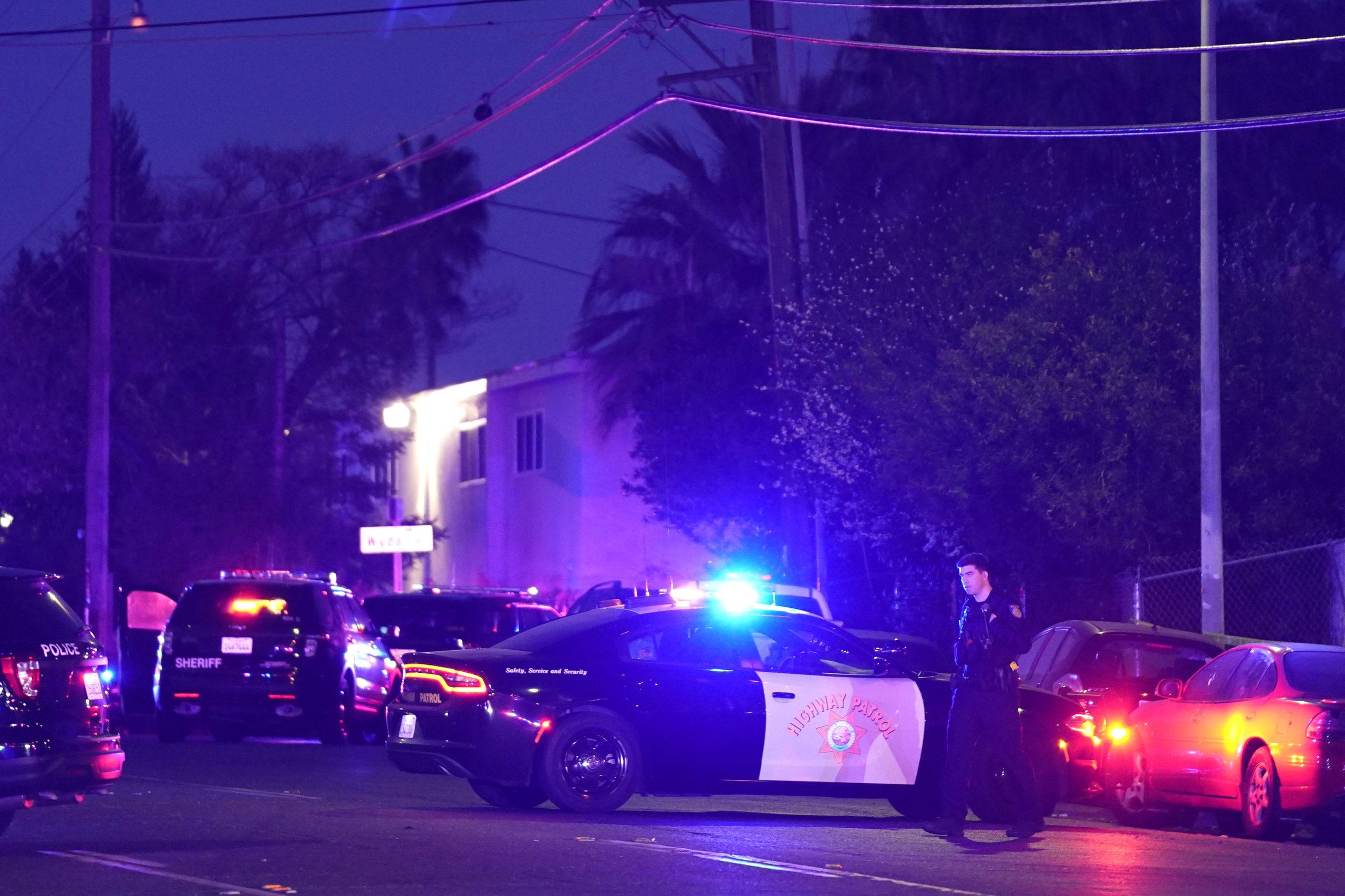 Law enforcement vehicles from several agencies block a street near the scene of a shooting in Sacra...