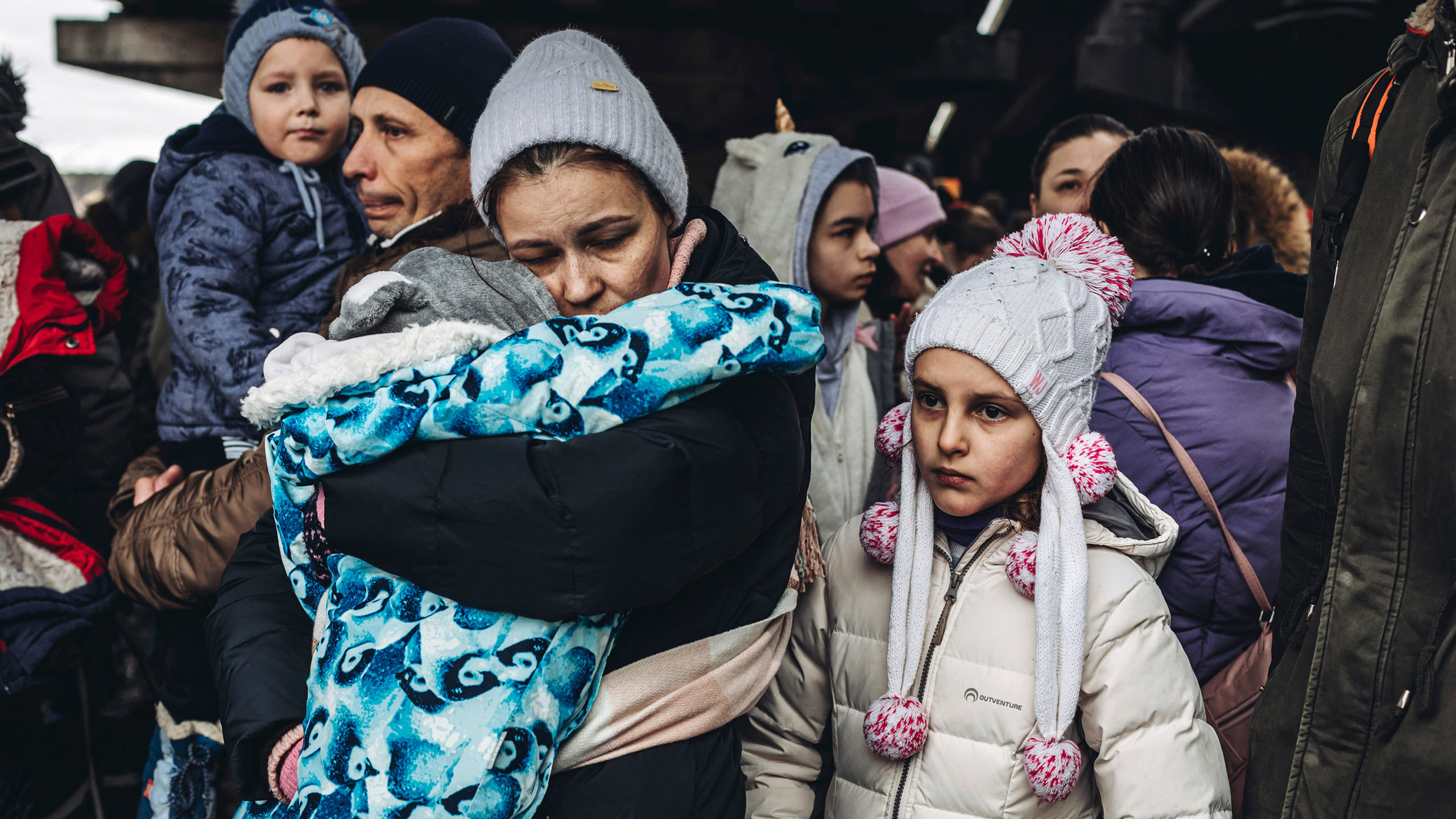 People with children wait to cross the Irpin river, March 5, 2022, in Irpin, Ukraine. The Ukrainian...