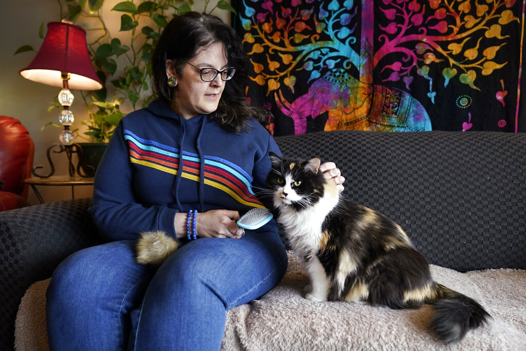 Tara Kramer sits in her apartment with her cat Busy, Friday, April 8, 2022, in Des Moines, Iowa. Mo...