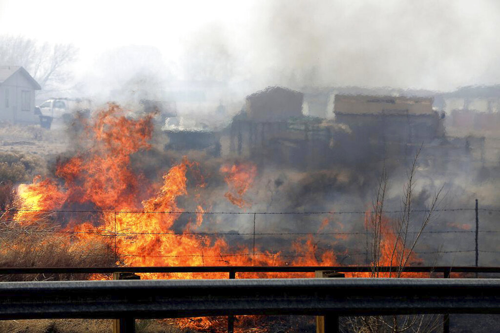 A wind-driven wildfire burns at the edge of U.S. 89 on the outskirts of Flagstaff, Ariz., on Tuesda...