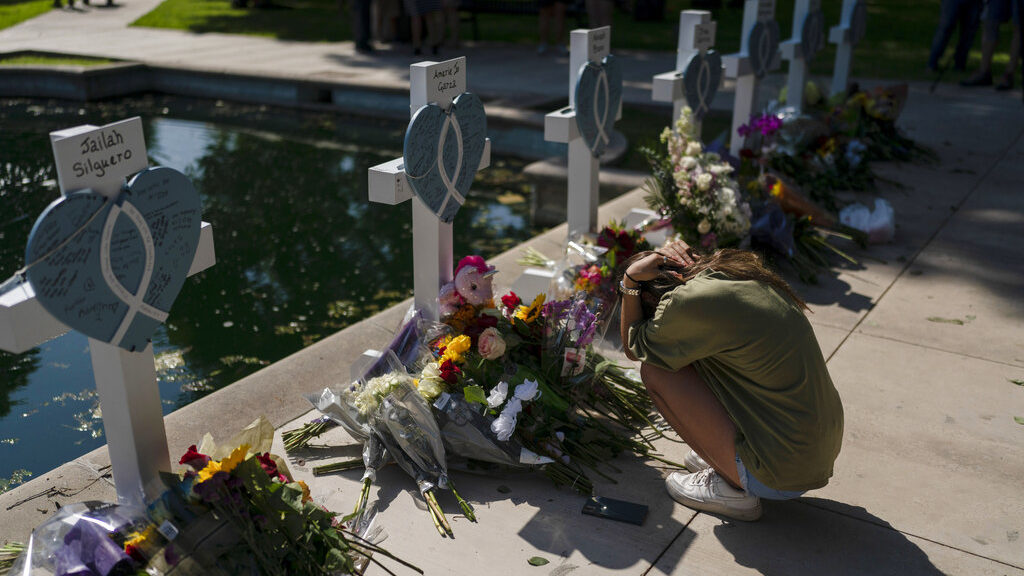Elena Mendoza, 18, grieves in front of a cross honoring her cousin, Amerie Jo Garza, one of the vic...