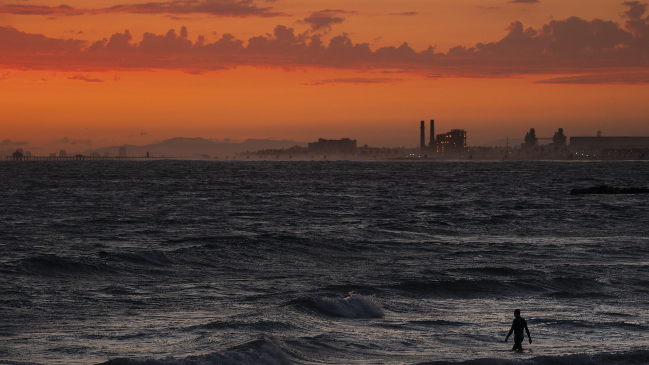 FILE - A man wades into the ocean at sunset on June 22, 2021, in Newport Beach, Calif. The National...